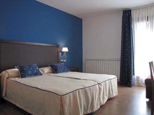 Sesué塞苏埃酒店的一间卧室配有一张带蓝色墙壁的大床