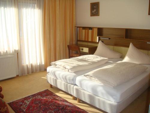 巴德小基希海姆Haus Anni的配有白色枕头的酒店客房内的两张床