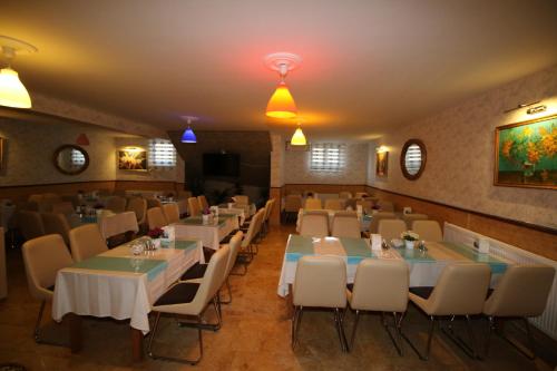 埃迪尔内Selimiye Hotel的一间在房间内配有桌椅的餐厅