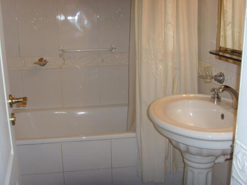 门多萨Apartamento DELUXE Edificio Millenium的一间带水槽、浴缸和卫生间的浴室