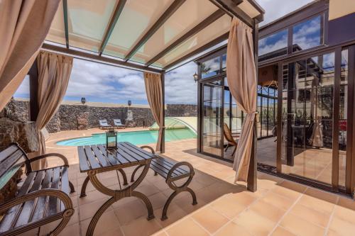 特吉塞Luxury Canarian villa with large pool or cozy apartment in Costa Teguise的一个带桌椅的室内庭院和一个游泳池