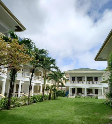 长滩岛Bans Boracay的一座大白色的建筑,在院子里种有棕榈树