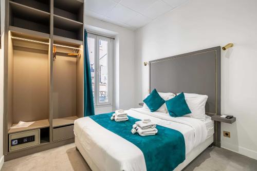 戛纳Hotel Avaton - 1 min du Palais - Cannes Centre的一间卧室配有一张大床和毛巾