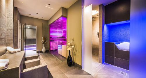 福森霍普芬斯酒店的浴室拥有紫色照明和步入式淋浴间。
