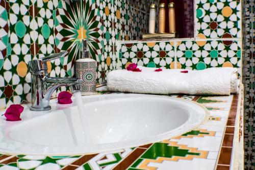 瓦尔扎扎特Le Petit Riad Maison d'hôtes的一间带水槽和瓷砖墙的浴室