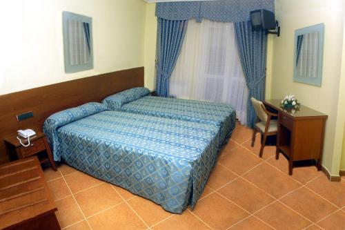 贝纳文特卡斯蒂利亚旅馆的一间卧室配有一张床、一张书桌和一个窗户。