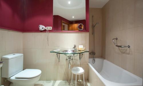 马德里雅典娜太阳门酒店的浴室配有卫生间、盥洗盆和浴缸。