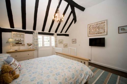 沃里克Daisy Cottage的一间卧室配有一张大床和电视