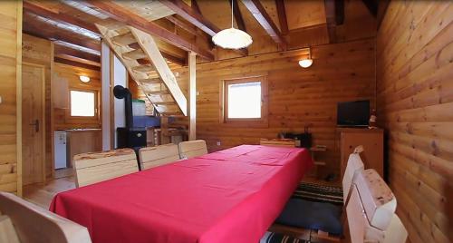 弗济内Chalets Zelena Vrata的一间用餐室,配有红色的桌子和椅子