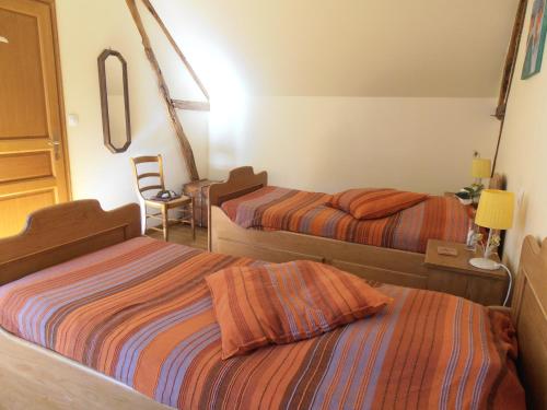 Abbecourt勒斯梅勒特斯乡村度假屋的一间卧室配有两张床和一张带台灯的桌子