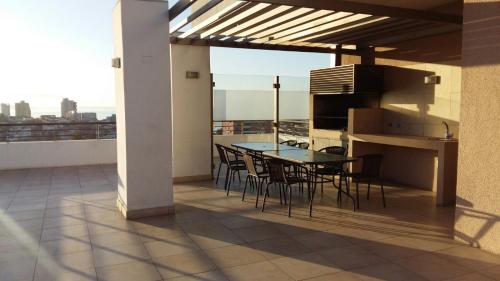 维纳德马Apartamento En Viña Del Mar的阳台的天井配有桌椅