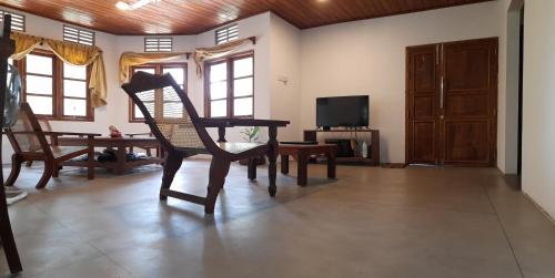 Kalutara NorthRustic Villa In Kalutara South的客厅配有桌椅和电视。