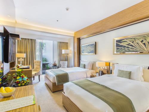 桑托斯将军城江珊绿叶酒店的酒店客房设有两张床和电视。