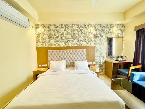 普里HOTEL PETAL ! PURI होटल पेटल হোটেল পাপড়ি హోటల్ పెటల్ fully-air-conditioned-hotel with-lift-and-parking-Card Payment Accepted-facility breakfast-included Best Hotel in Puri 2的酒店客房带一张大床和一把椅子