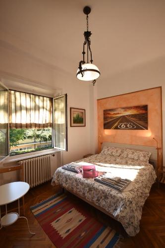 瓦雷泽Invilla B&B的卧室配有床、桌子和窗户。