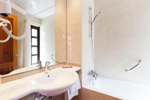 塔拉戈纳普拉萨德拉丰特酒店的白色的浴室设有水槽和淋浴。