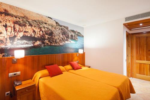 塔拉戈纳普拉萨德拉丰特酒店的卧室配有一张黄色的床,墙上挂着一幅画