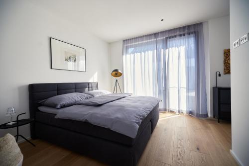 萨尔茨堡Designapartment Salzburg的一间卧室设有一张床和一个大窗户