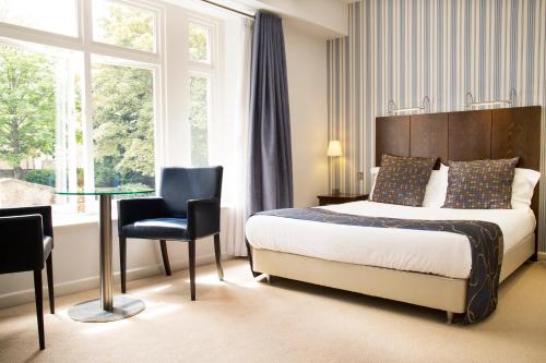 约维尔Lanes Hotel的酒店客房设有一张床铺和一张玻璃桌
