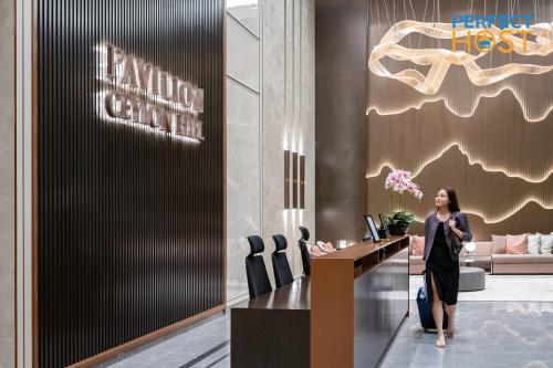 吉隆坡Pavilion Ceylon Hill Suites, Bukit Bintang的站在大堂桌子上的女人