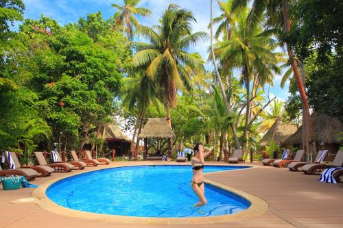 Toberua托伯岛度假酒店的站在游泳池前的比基尼女人