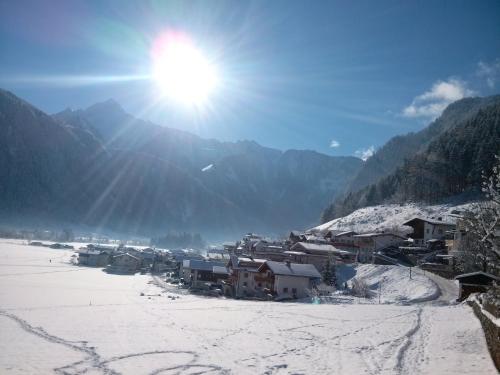 迈尔霍芬Ferienwohnung Zuppinger的雪中的一个村庄,天空中阳光灿烂