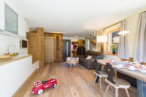 塞尔瓦迪加尔代纳山谷Chalet Da Mont的厨房以及带红色玩具车的客厅。