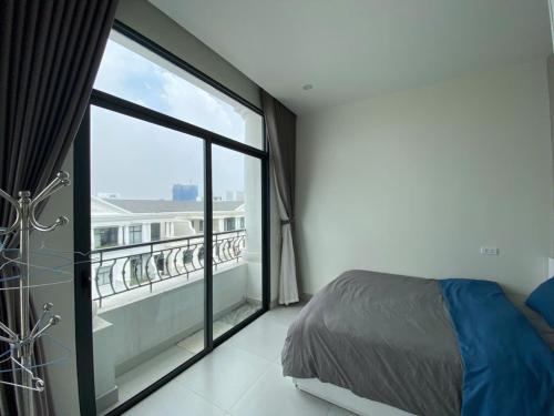 海防Chuỗi căn hộ Space Apartment & Homestay tại Vinhomes Marina Hải Phòng的一间卧室设有一张床和一个大窗户