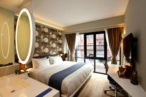 纽约诺贝尔DEN酒店的一间卧室配有床、水槽和镜子