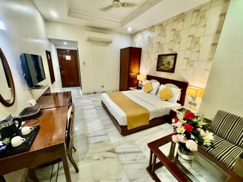 新德里GTB Florence Inn, 2min walk from Karol Bagh Metro的配有一张床和一张书桌的酒店客房