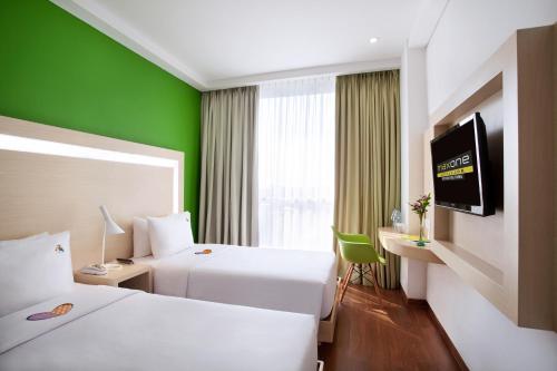 丹戎潘丹贝尔斯塔贝腾酒店的酒店客房设有两张床和绿色的墙壁。