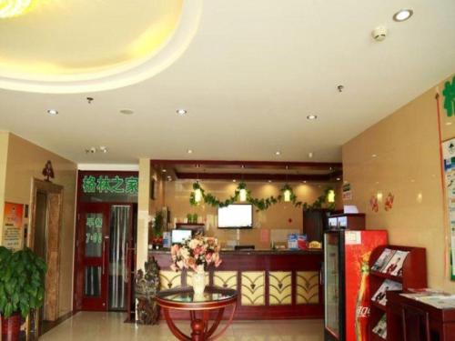 天津GreenTree Inn Tianjin Jinnan Shuanggang Lishuang Road Shell Hotel的餐厅的大堂,带鲜花桌