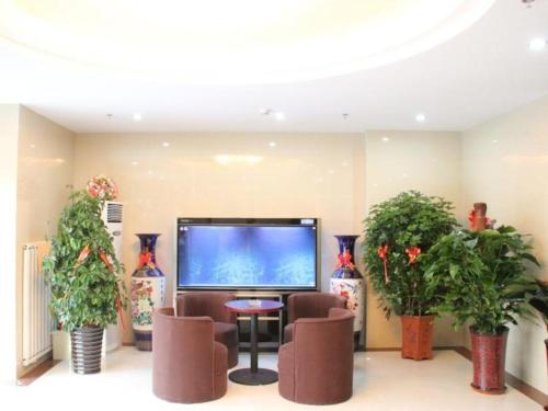 天津GreenTree Inn Tianjin Jinnan Shuanggang Lishuang Road Shell Hotel的大堂配有平面电视和植物。