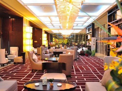 长沙Changsha Huatian Hotel的大楼内带桌椅的大堂