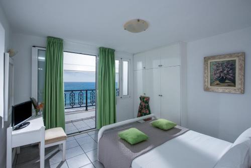 赫索尼索斯索尼娅别墅酒店的一间卧室设有一张床和一个海景阳台