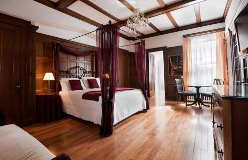 蒙特利尔阿高特酒店的一间卧室配有一张床和一张桌子及椅子