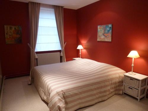 Ramillies尚特兰乡村民宿的一间卧室设有一张红色墙壁和窗户的床