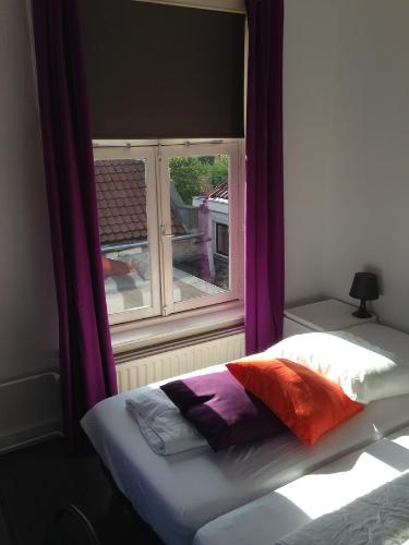 泽芬贝亨贝佛胡芬酒店的一张位于带紫色窗帘窗户的房间里的床