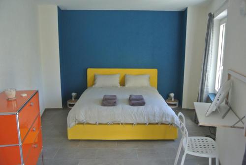 Miglieglia卡巴拉德设计公寓的一间卧室配有一张黄色的床和蓝色的墙壁