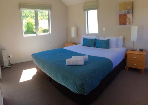 箭镇艾罗菲尔德公寓酒店的一间卧室配有一张带蓝色毯子的大床