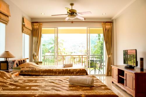 邦涛海滩Baan Rosa Bangtao Beach的一间带两张床的卧室和一个阳台