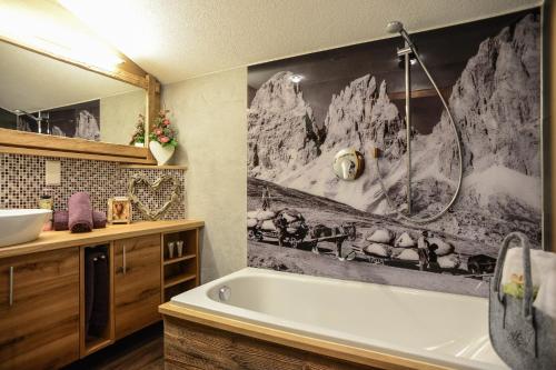 容霍尔茨安格公寓 - 浪漫 - 美容 - 康体的带浴缸的浴室和一幅山脉画