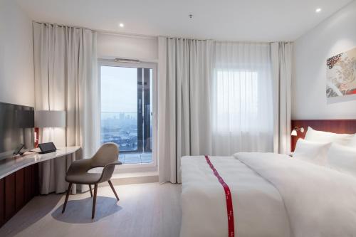 维也纳红宝石玛丽维也纳酒店的配有一张床、一张书桌和一扇窗户的酒店客房