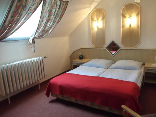 SewekowSeehotel Ichlim的一间卧室配有一张带红色毯子的床