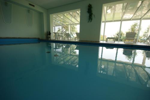 巴彻尔堡Hotel Beinbauer的水中反射的房屋内的游泳池