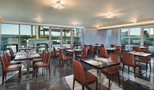 迪拜阿塔纳酒店的餐厅设有桌椅和窗户。