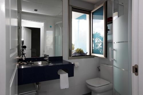 拉曼加戴尔马尔梅纳Gran Lugar -Mar Azul的一间带水槽和卫生间的浴室以及窗户。