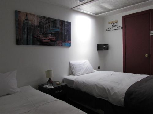 圣费尔南多Hotel Central San Fernando的酒店客房设有两张床,墙上挂有绘画作品
