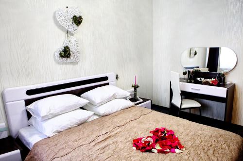 巴尔瑙尔普雷斯提吉酒店的一间卧室配有一张带鲜花的大床
