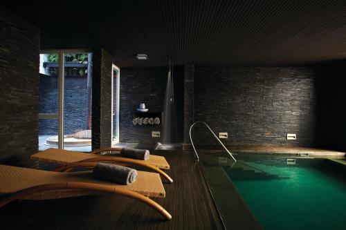 瓦尔帕莱索阿斯托雷卡宫酒店的一个带椅子的游泳池和一个游泳池的房间